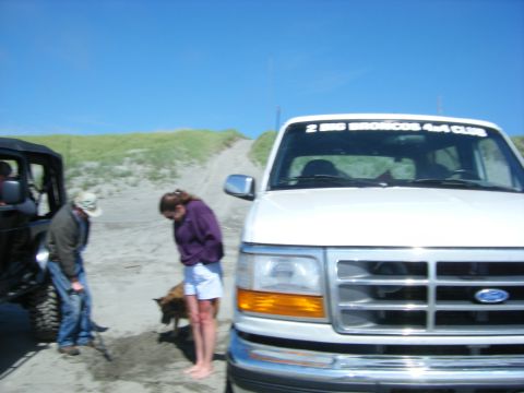 1994 Ford Explorer - White 1997 Ford F-150 with club sticker parked on sand next to a Jeep.