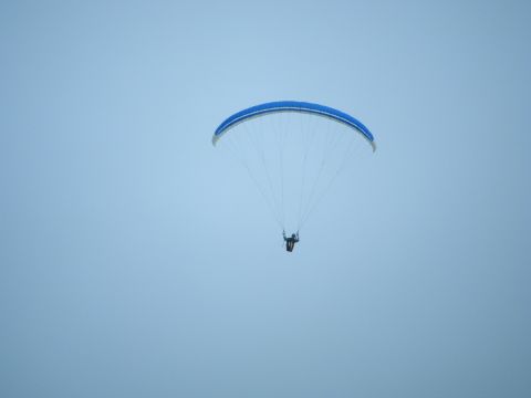 1994 Ford Explorer - A paraglider is suspended in the air against a clear sky.