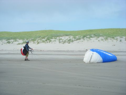1994 Ford Explorer - A paraglider prepares for flight on a sandy beach next to a deployed parachute.