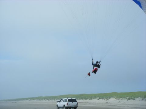 1994 Ford Explorer - Paraglider in the air above a white SUV on a beach.