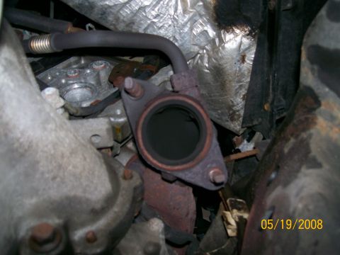 1995 Mercury Grand Marquis - Close-up view of a vehicle's exhaust pipe connection, showing signs of wear and tear.