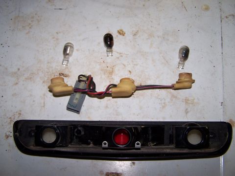1995 Ford C-350 (Centurion Conversions) - Disassembled vehicle light assembly and bulbs laid out on a surface.