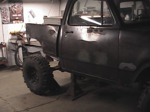 1980 Dodge Magnum - This Dodge pickup truck is in a garage, supported by jack stands, with its rear fender removed and bodywork visible.