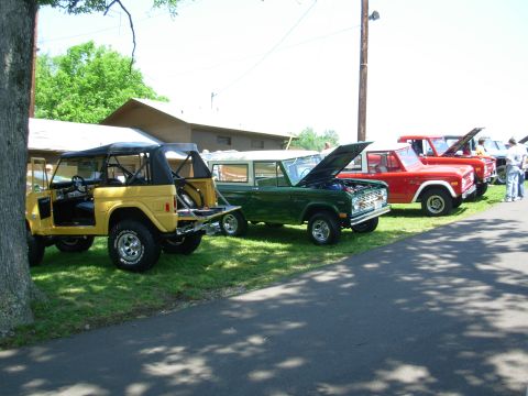 1983 Ford Bronco - Multiple Ford Broncos displayed at an event, with hoods open on some.