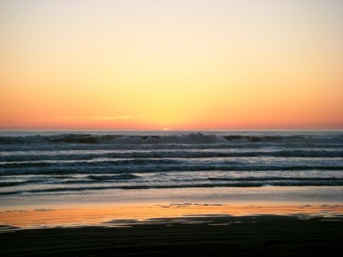 1994 Ford Explorer - Waves crash on the shore during a vibrant sunset over the ocean.