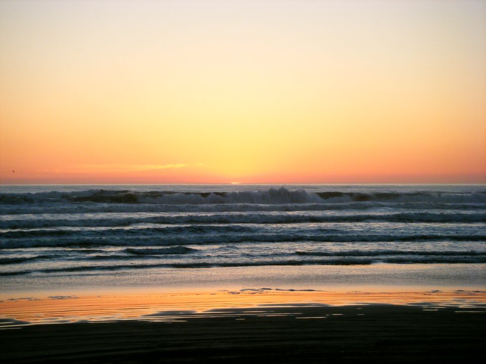 Ocean waves at sunset with orange and yellow sky