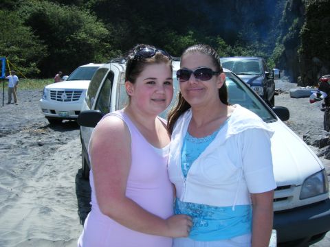 1994 Ford Explorer - Two women stand in front of a white minivan on a sandy beach, with a white SUV visible behind them.