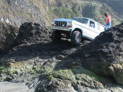 1978 Ford Bronco - A lifted 1978 Ford Bronco navigates a challenging rocky coastal path.
