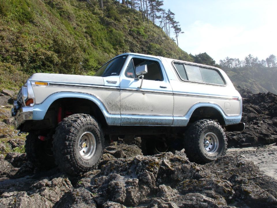 White and blue 1978 Ford Bronco lifted on rocks