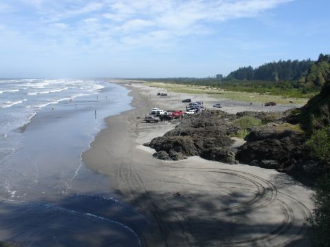 1978 Ford Bronco - Vehicles gathered on a beach, with tire tracks visible in the sand.