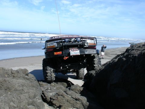 1978 Ford Bronco - A modified Ford Bronco navigates a rocky shoreline with the ocean in the background.
