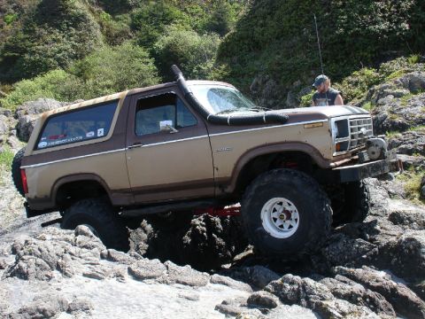 1978 Ford Bronco - A modified Ford Bronco navigates a rocky, coastal path.
