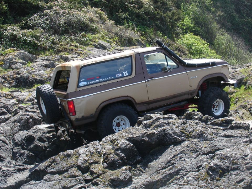 1978 Ford Bronco with snorkel driving over rocks