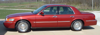 1999 Mercury Grand Marquis - A red 1999 Mercury Grand Marquis sedan is shown from the side.