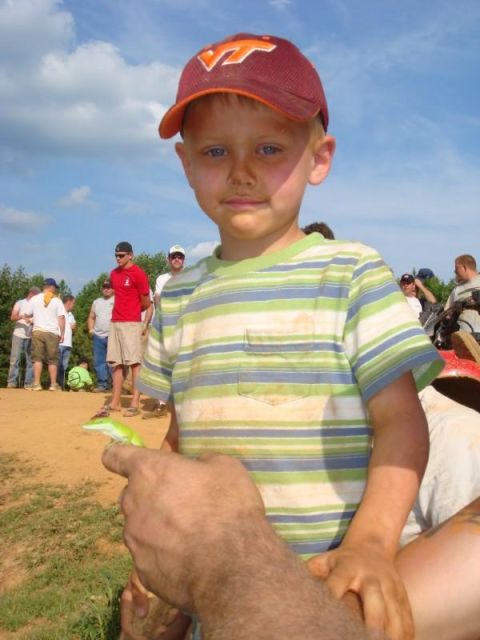 1978 Ford Bronco - A young boy proudly displays a small green lizard he found outdoors.