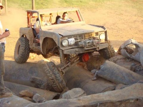 1978 Ford Bronco - This modified 1978 Ford Bronco tackles a challenging off-road course with its front tire elevated.