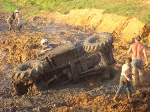 1978 Ford Bronco - A tractor is stuck in thick mud, with several people observing the scene.