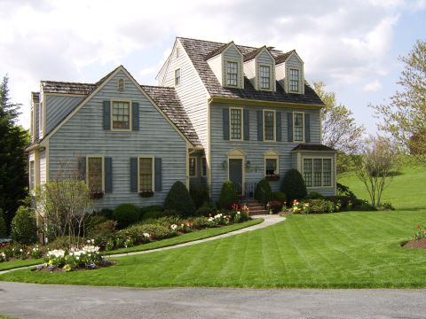 1996 Mercury Grand Marquis - A well-maintained house with a winding walkway and lush landscaping under a partly cloudy sky.