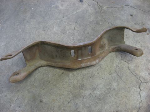 1978 Ford Mustang II - A weathered metal bracket, likely a vehicle part, lies on a cracked concrete surface.