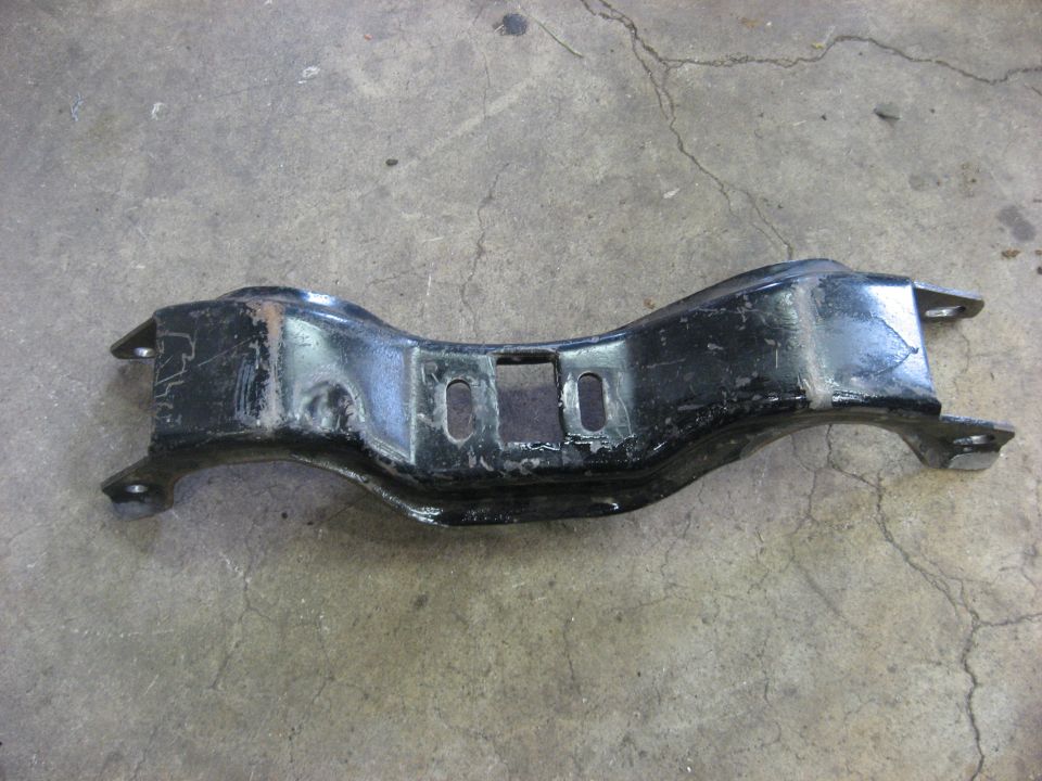 Black metal automotive part on concrete floor