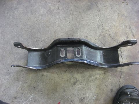 1978 Ford Mustang II - A metal bracket is shown lying on a concrete floor.