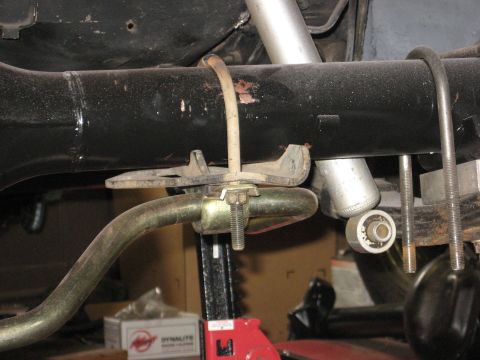 1978 Ford Mustang II - Undercarriage view showing suspension parts, including a sway bar and shock absorber, held by a jack.