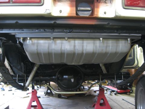 1978 Ford Mustang II - The underside of a vehicle displays a newly installed gas tank, supported by jack stands.