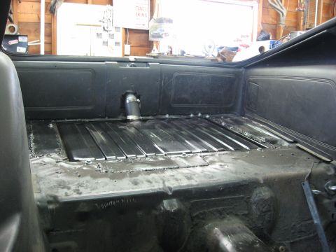 1978 Ford Mustang II - The trunk of a car is shown with a newly installed metal floor and a fuel filler pipe protruding from the side.