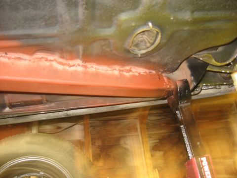 1978 Ford Mustang II - Underbody view shows a red-painted frame rail and a tire, with a jack supporting the vehicle.