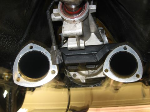 1978 Ford Mustang II - The underside of a vehicle shows the transmission housing and the flanges for two exhaust pipes.