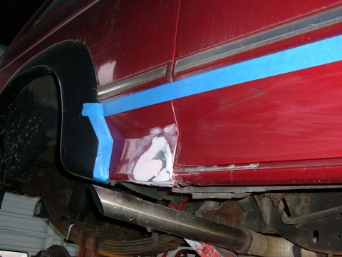 1994 Ford Bronco - Rust repair in progress on the side panel of a 1994 Ford Bronco, with blue tape masking the area.