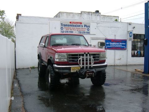 1994 Ford Bronco - This lifted 1994 Ford Bronco features a winch and is parked in front of a repair shop.