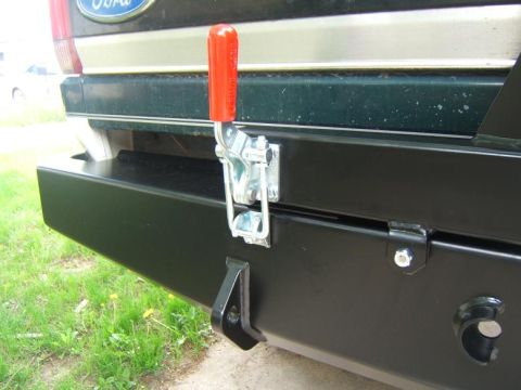 1993 Ford Bronco - Rear view of a 1993 Ford Bronco showing a black aftermarket bumper with a red-handled latch and tow hook.