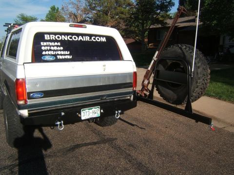 1993 Ford Bronco - Rear view of a modified Ford Bronco showing a spare tire carrier and Hi-Lift jack mounted.