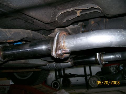 1995 Mercury Grand Marquis - Underside view of a car on stands showing a dual exhaust routed along the floor pan, with a fresh aluminized pipe joined to a darker pipe b…