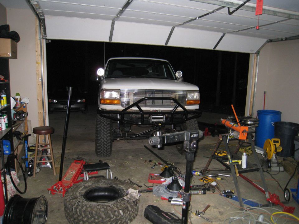 White 1996 Ford Bronco front view with aftermarket bumper and winch in garage