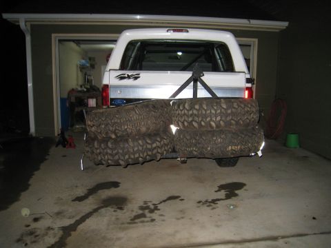 1996 Ford Bronco - Night shot of a white full-size Ford SUV backed into a garage, photographed from directly behind with the tailgate '4X4' badge and Ford ova…