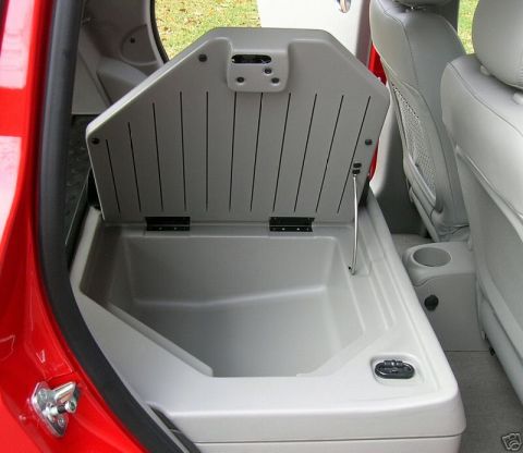 1991 Ford Crown Victoria - Open storage compartment in the rear interior of a car, showing a plastic bin.