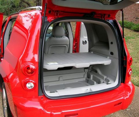 1991 Ford Crown Victoria - The rear storage area of a red SUV is shown with the liftgate open, revealing a removable cargo shelf.
