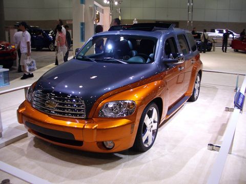 1991 Ford Crown Victoria - This two-tone orange and grey SUV features a prominent grille and sunroof, displayed indoors.