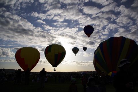 1995 Ford Bronco - A fleet of hot air balloons takes flight at sunrise, with spectators gathered below.