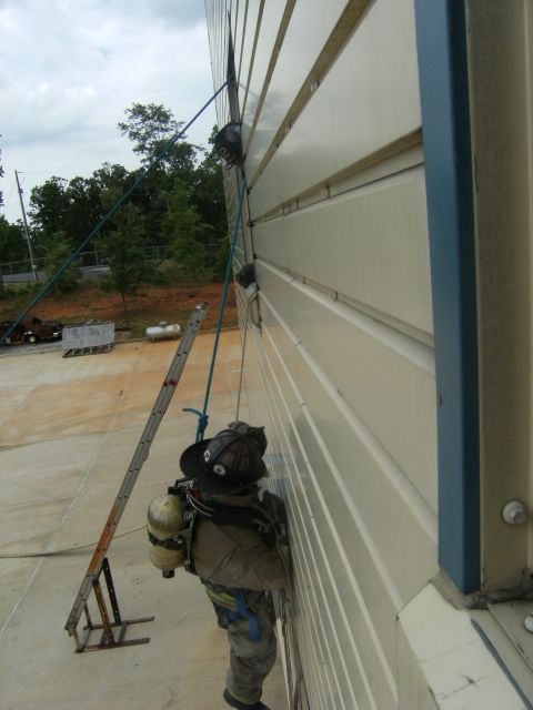 1992 Ford F-150 - Firefighter rappelling down a building wall using ropes and equipment.