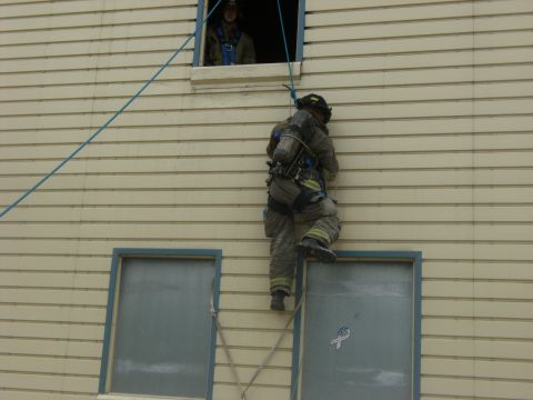1992 Ford F-150 - A firefighter descends a building using a rope while another watches from an upper window.