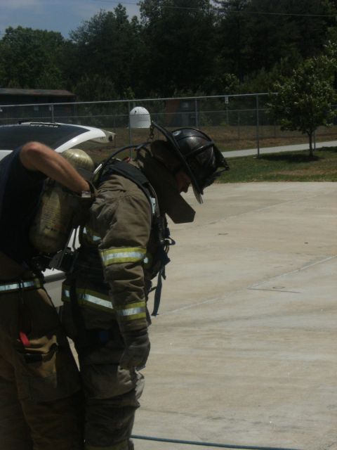 1992 Ford F-150 - A firefighter dons protective gear with assistance from a colleague, preparing for duty.