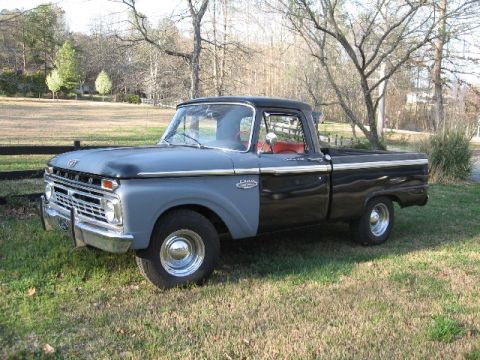 1966 Ford F-100 - Three-quarter front view of a black mid-1960s Ford F-100 shortbed pickup with gray primered front fenders and cab side, chrome grille, stee…