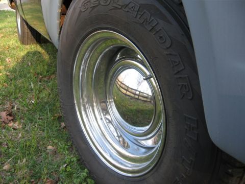 1966 Ford F-100 - Close-up of a deep-dish chrome moon-style hub cap on a vintage pickup wheel, wrapped in a Yokohama Geolandar H/T raised-white-letter tire,…