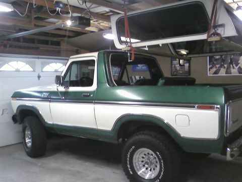 1978 Ford Bronco - This two-tone green and white 1978 Ford Bronco is shown in a garage with its removable top hoisted overhead.