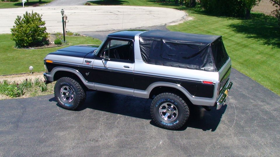Two-tone black and silver Ford Bronco with a black soft top, parked on a driveway