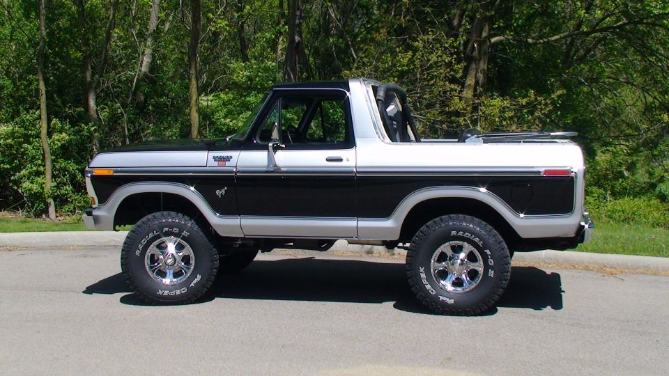 Side view of a lifted black and silver two-door Ford Bronco.