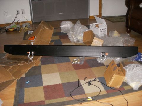 1989 Ford Bronco - A black aftermarket bumper is laid out on a colorful rug with various boxes and bubble wrap surrounding it. Two D-ring shackle mounts are v…